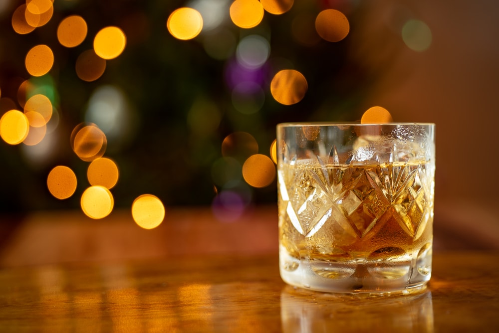 Bardstown Distilleries, a picture of a glass of bourbon with a Christmas tree behind it